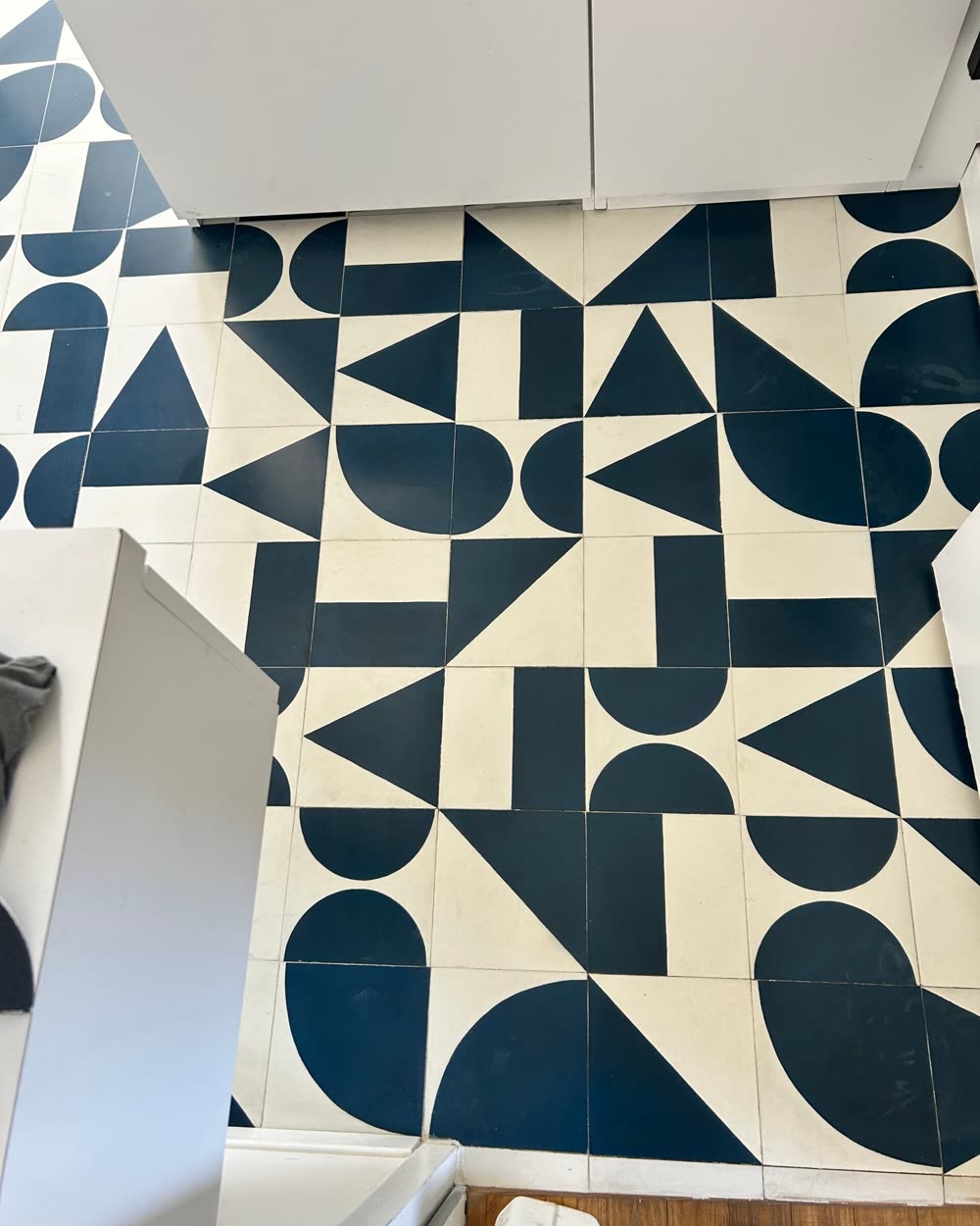 Carreaux de ciment à motif géométrique bleu et blanc, après nettoyage et protection.