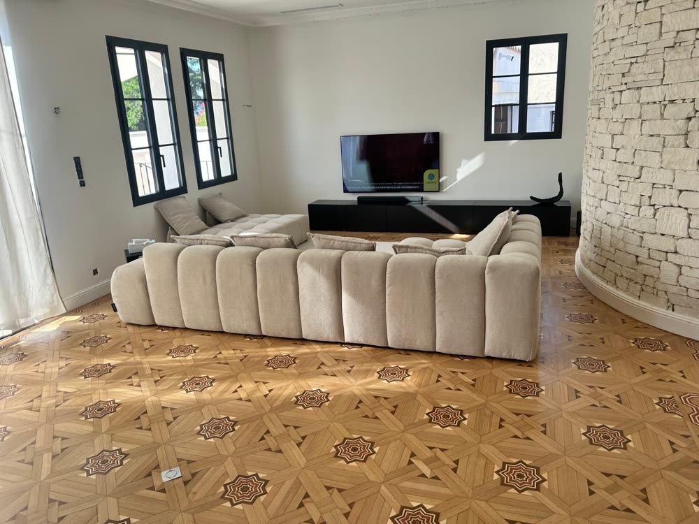 Salon avec carreaux de ciment à motif et parquet, après rénovation.