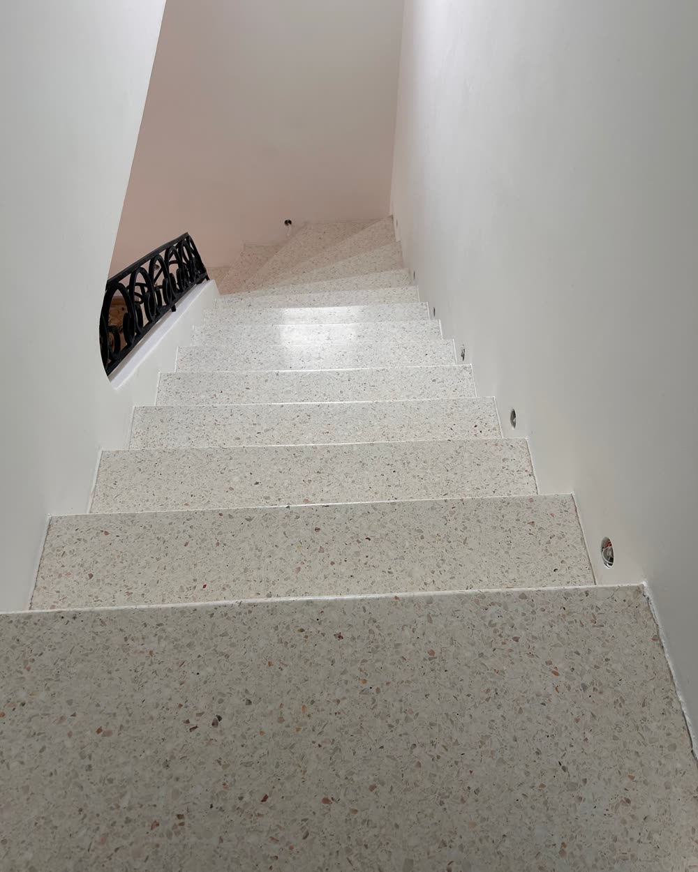 Escalier en granito blanc moucheté, garde-corps en fer forgé, après ponçage et polissage.