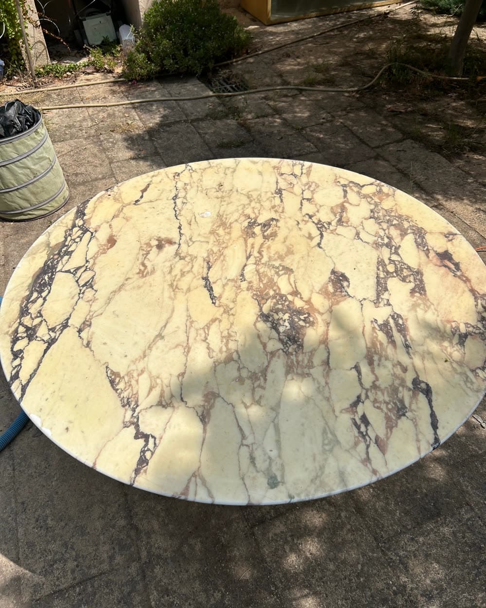 Table ronde en marbre, terne et tachée.