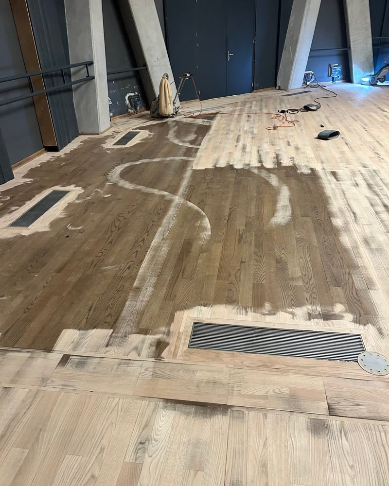 Parquet large lame à moitié poncé, chantier professionnel.