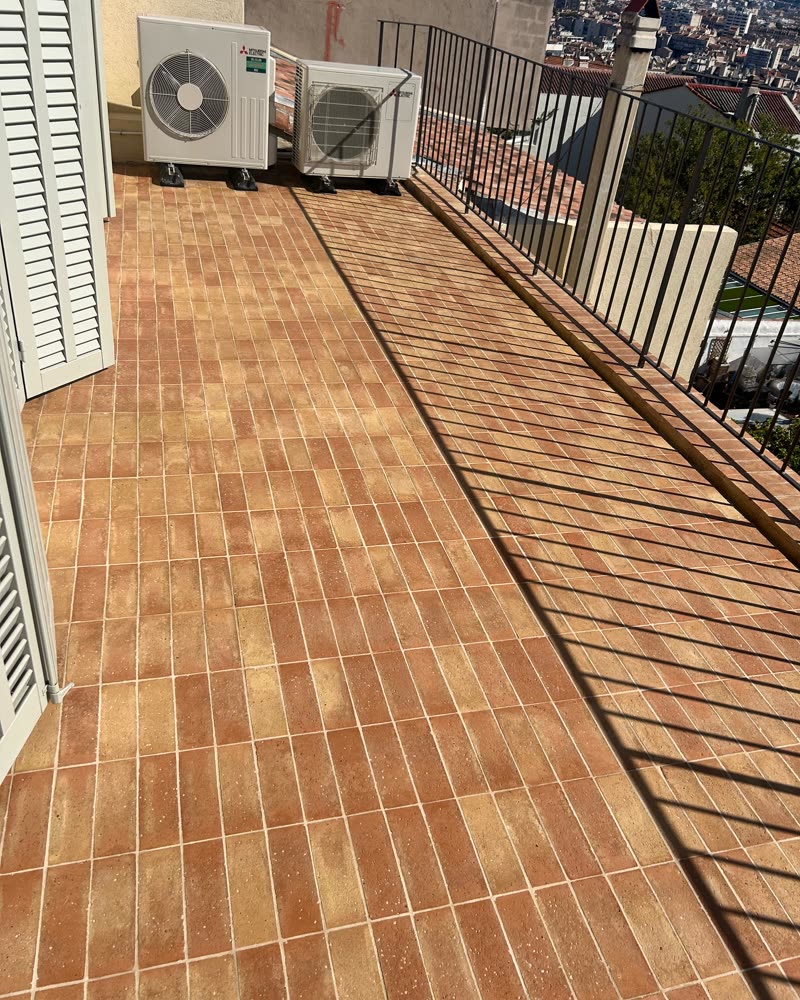 Balcon en terre cuite rénové, vue sur la ville.